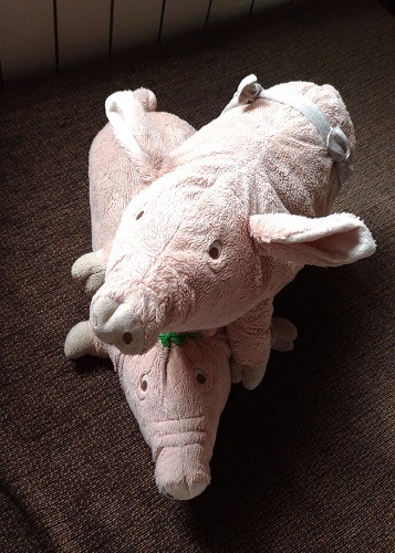 Two plush pig toys stacked on top of one another